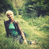 portrait-woman-smiling-while-sitting-grassy-field (1)